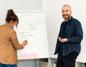Teilnehmer*innen am Flipchart in Weiterbildung im Bereich Personal / Organisation